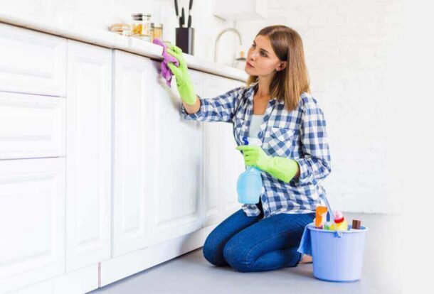 A woman from housekeeping services is cleaning the shelf