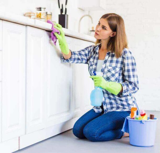 A woman from housekeeping services is cleaning the shelf