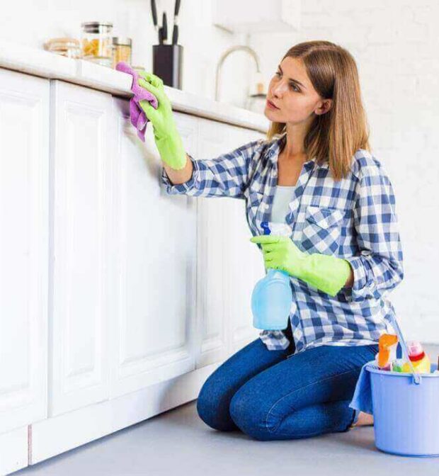 A woman from housekeeping services is cleaning the shelf