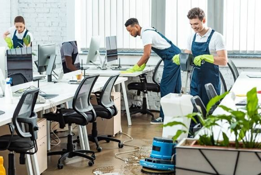 Three persons from housekeeping services are cleaning office